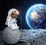 BRUBAKER Figurine Astronaut Sitting on The Moon Fishing for Stars - 6.7 Inch Spaceman Space Decor Figure with Fishing Rod and Chrome Plated Helmet - Hand Painted
